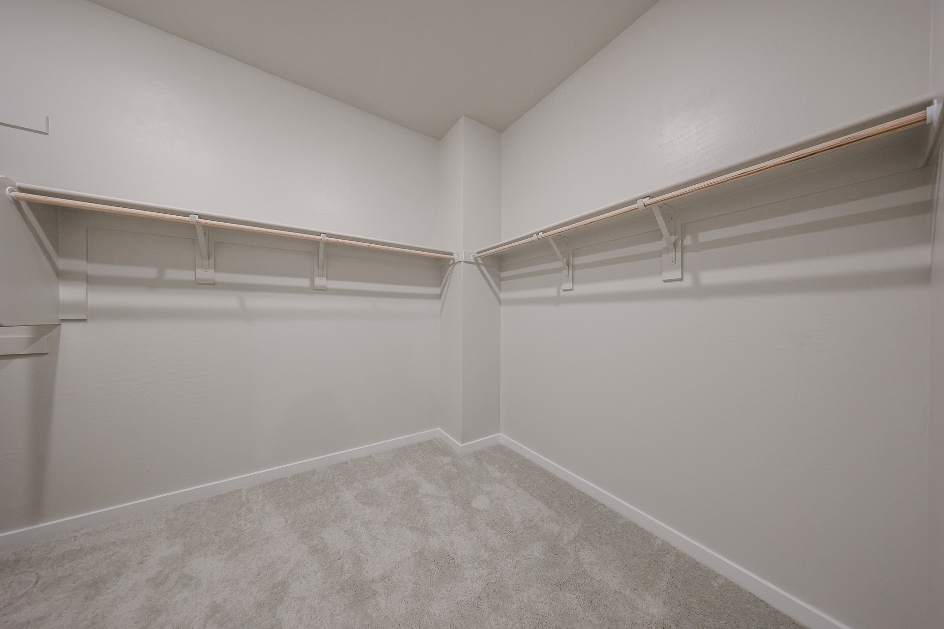 A white hallway with a metal railing.