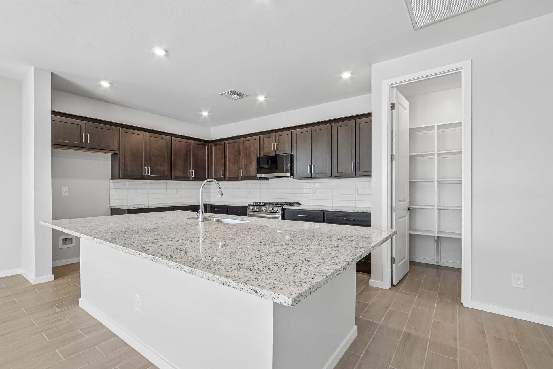 A kitchen with a marble counter top.