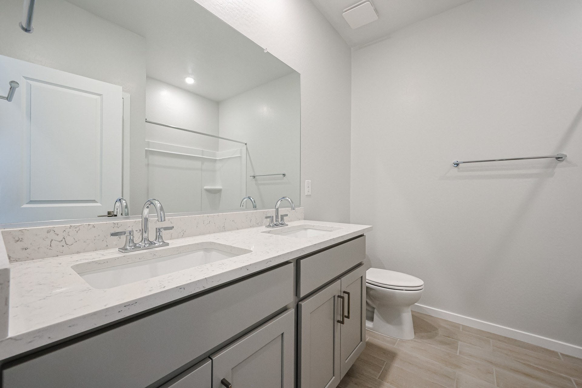 A bathroom with a sink toilet and mirror.