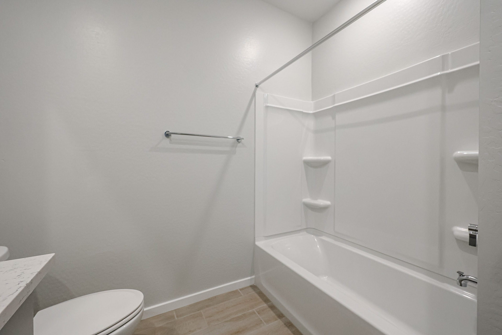 A bathroom with a shower unit and toilet.