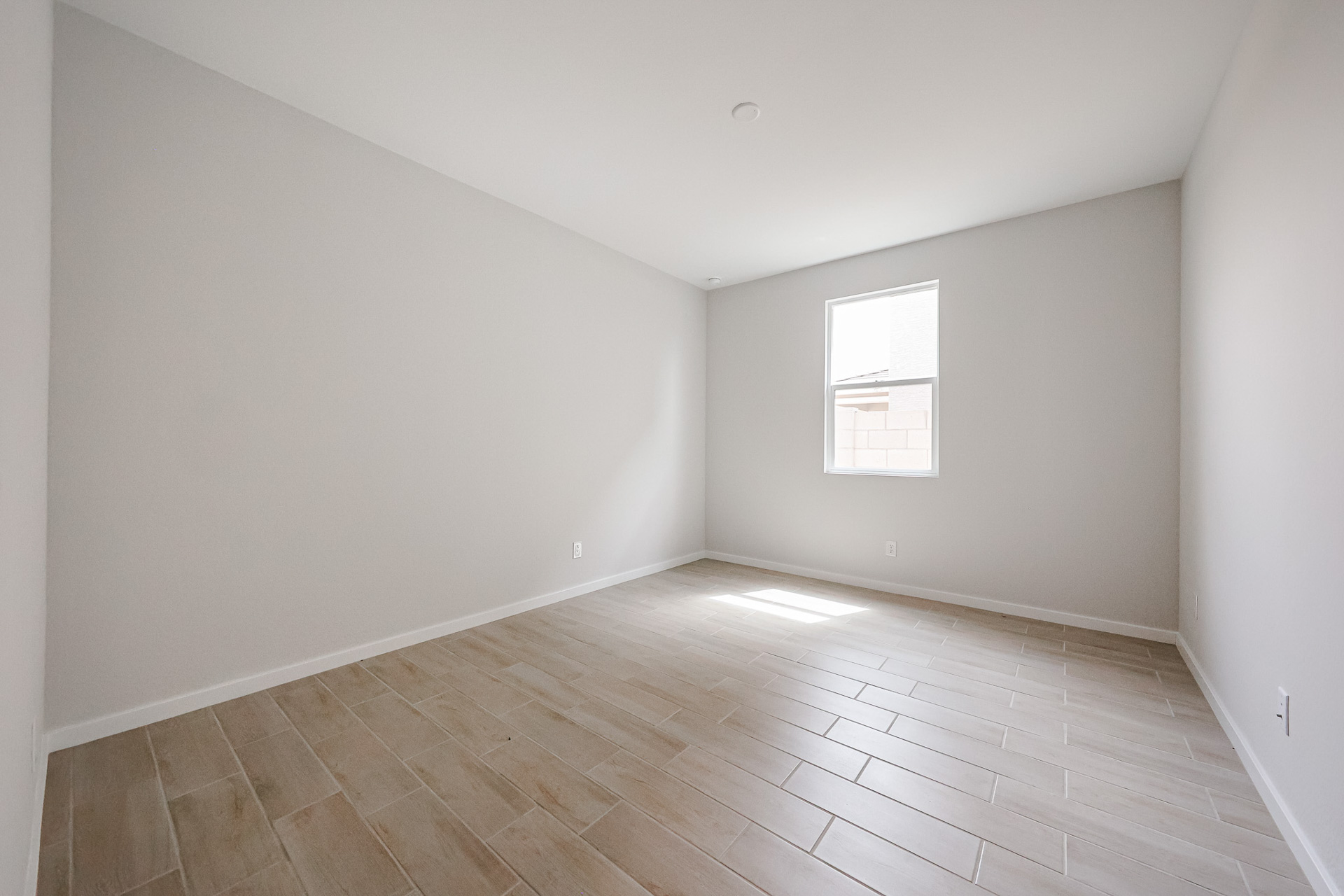 A room with a wood floor and white walls.
