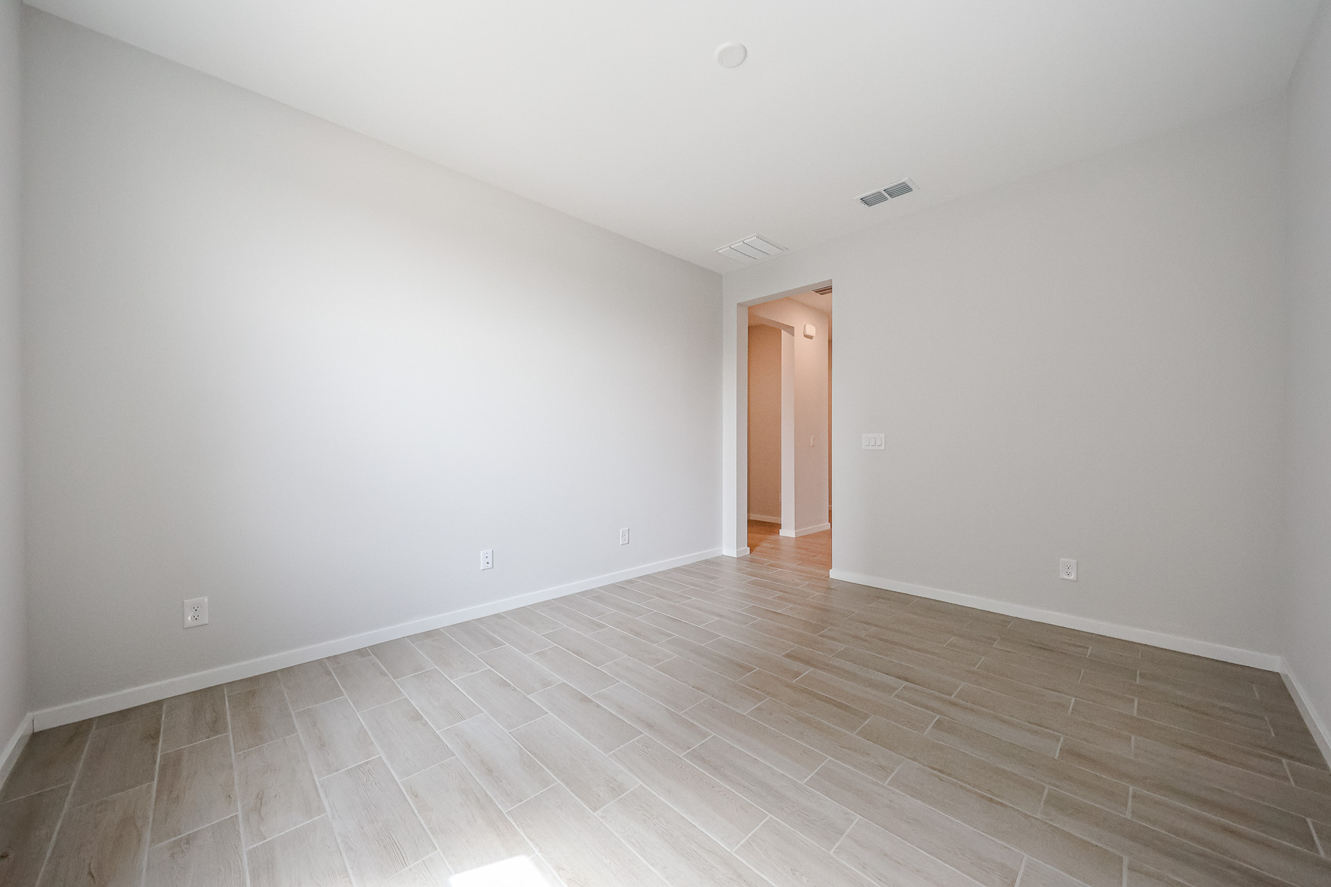A room with a wood floor and a wood door.