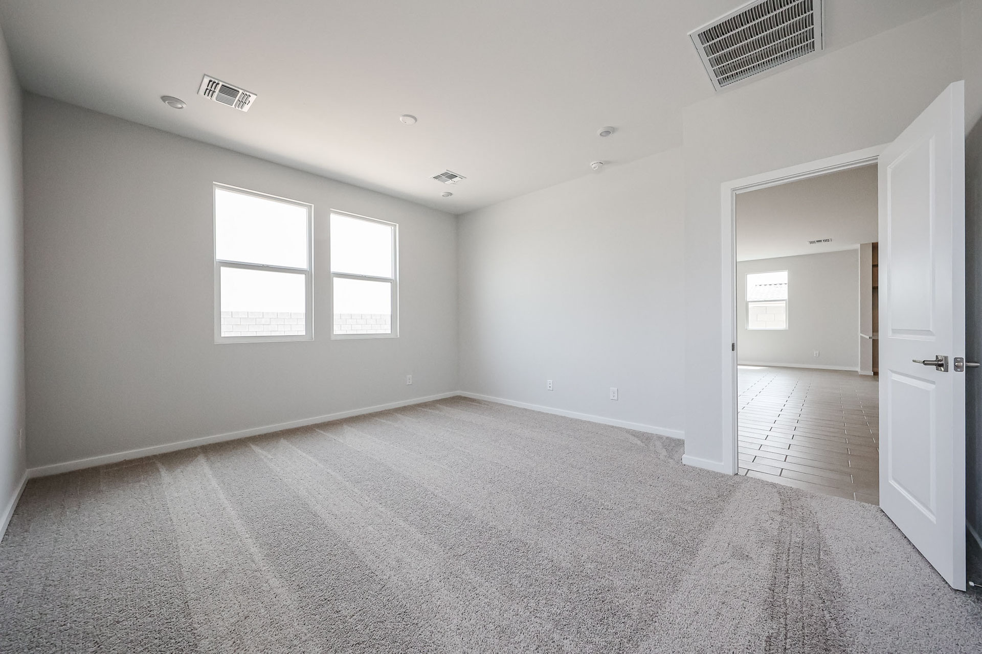 A room with a carpet and a door.