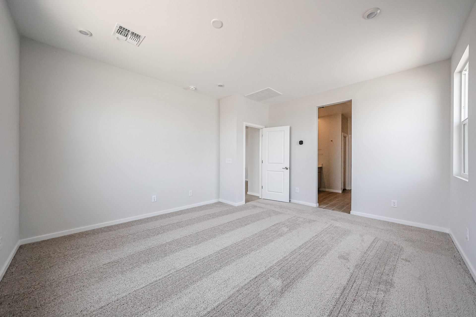 A long hallway with white doors.