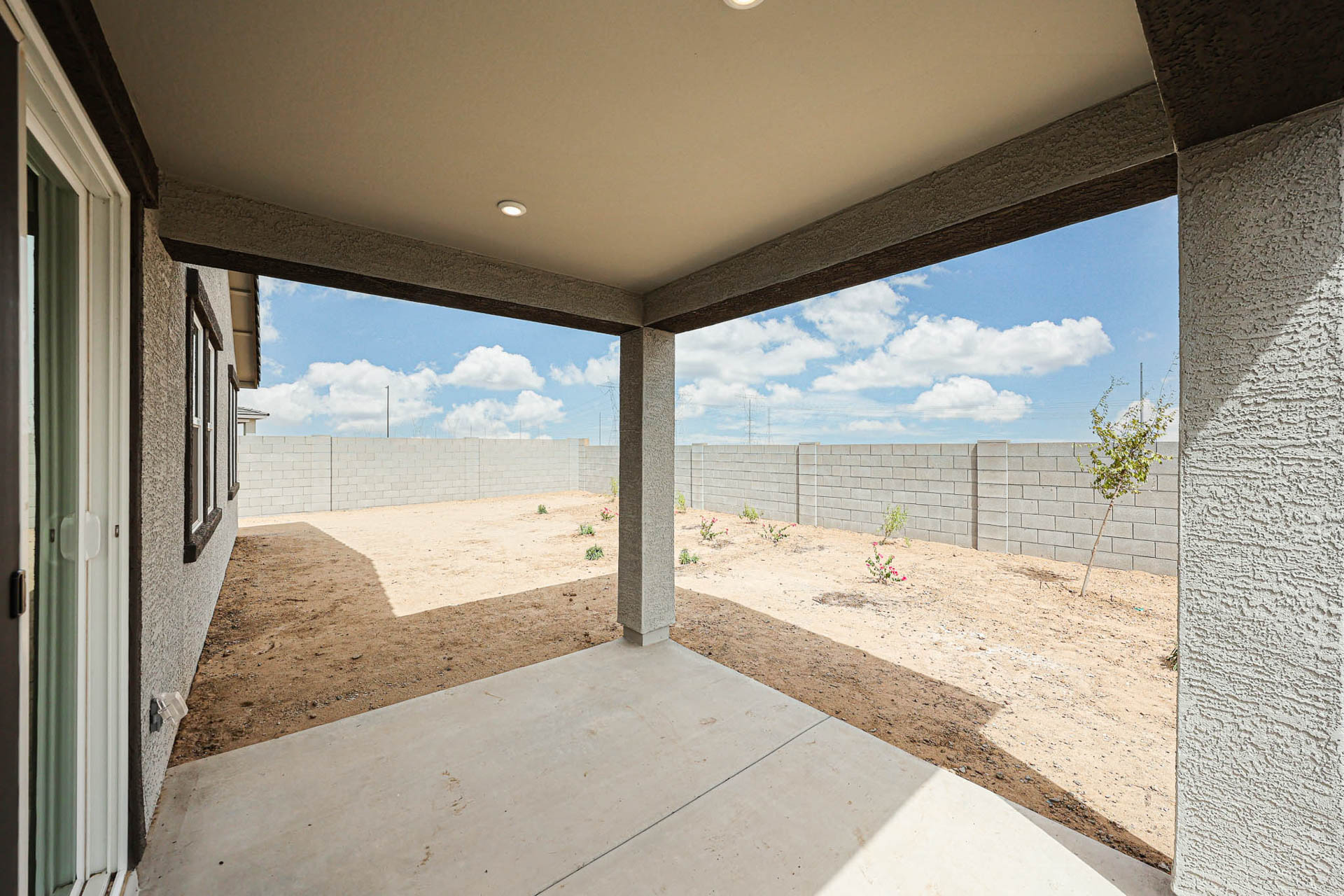 A concrete walkway with a fence and a field in the background.