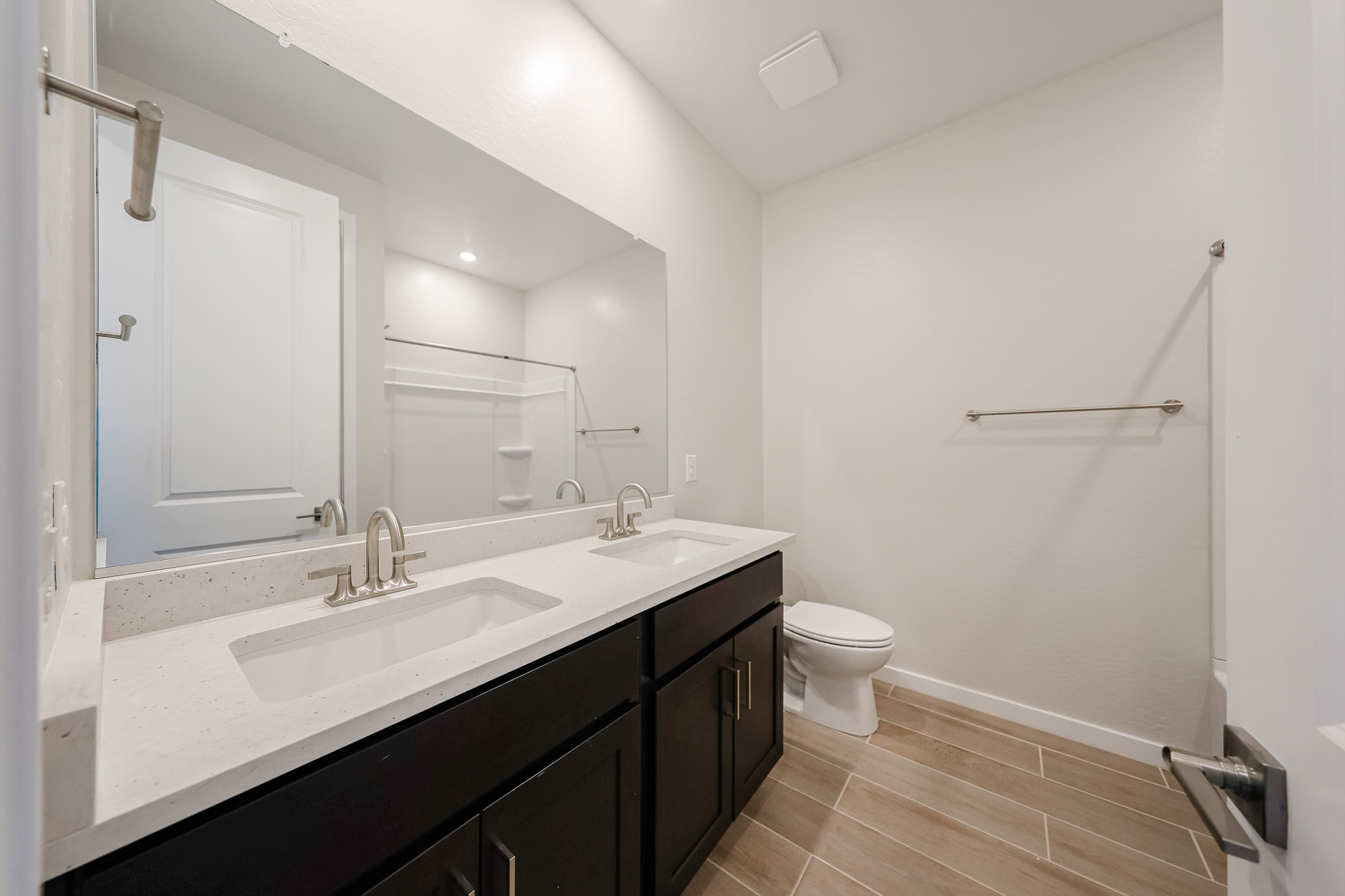A bathroom with a sink toilet and mirror.