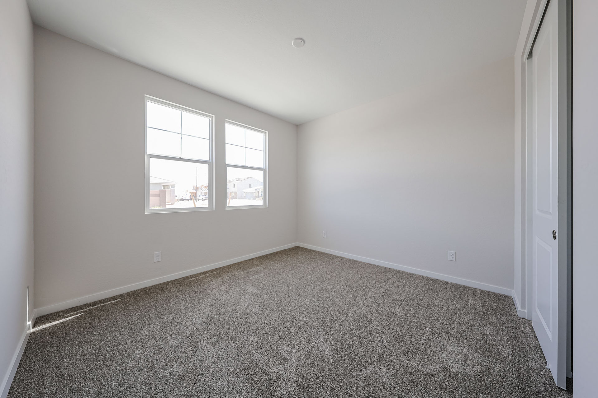 A room with a carpet and windows.