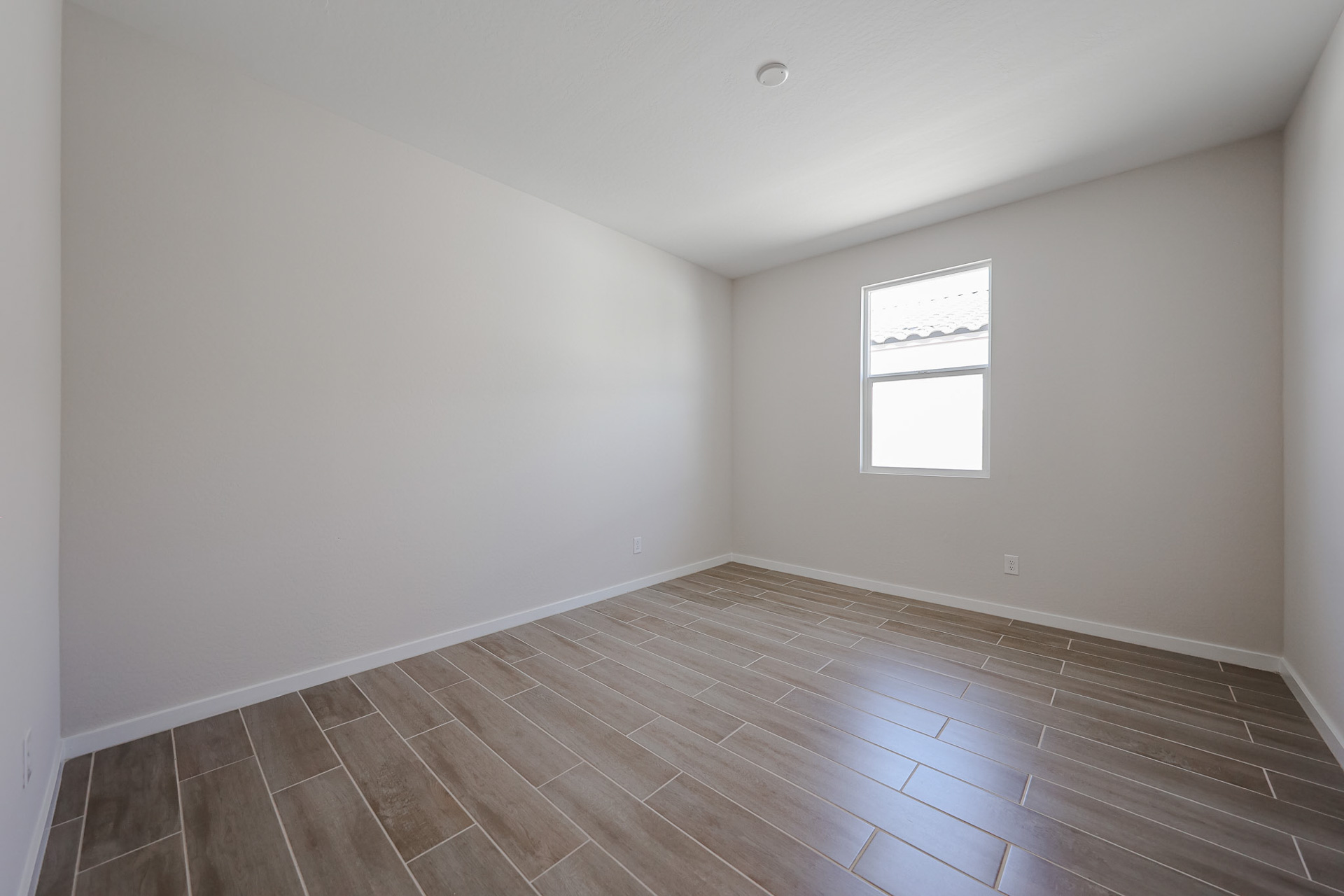 A room with a wood floor and windows.