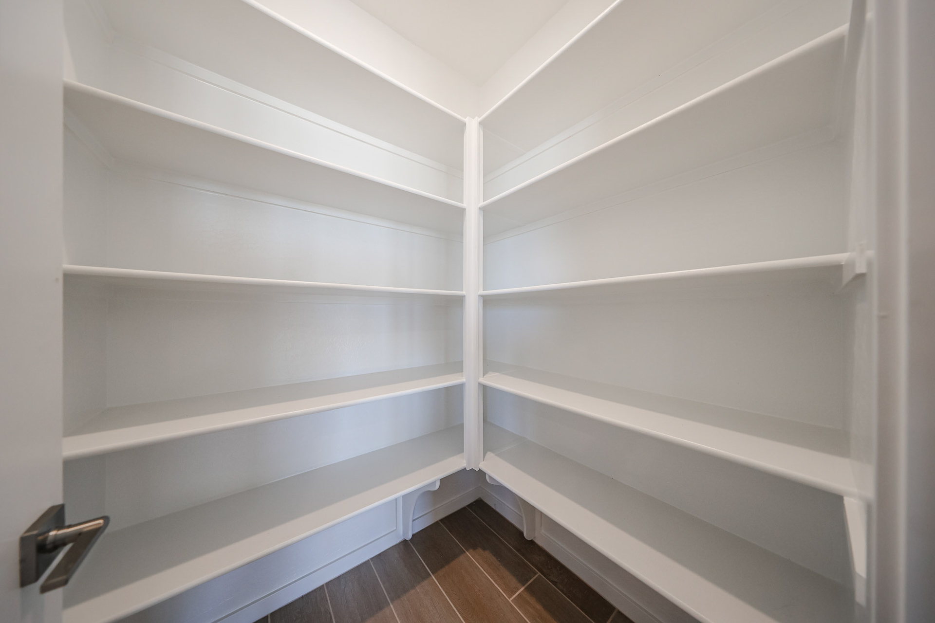 A white shelf with white walls.