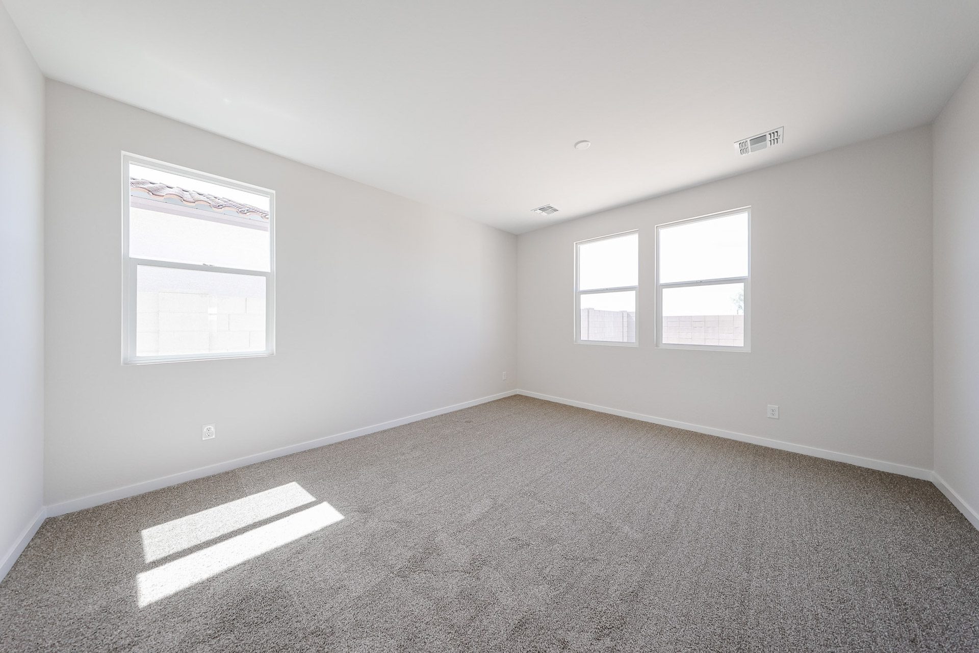 A room with a carpet and windows.