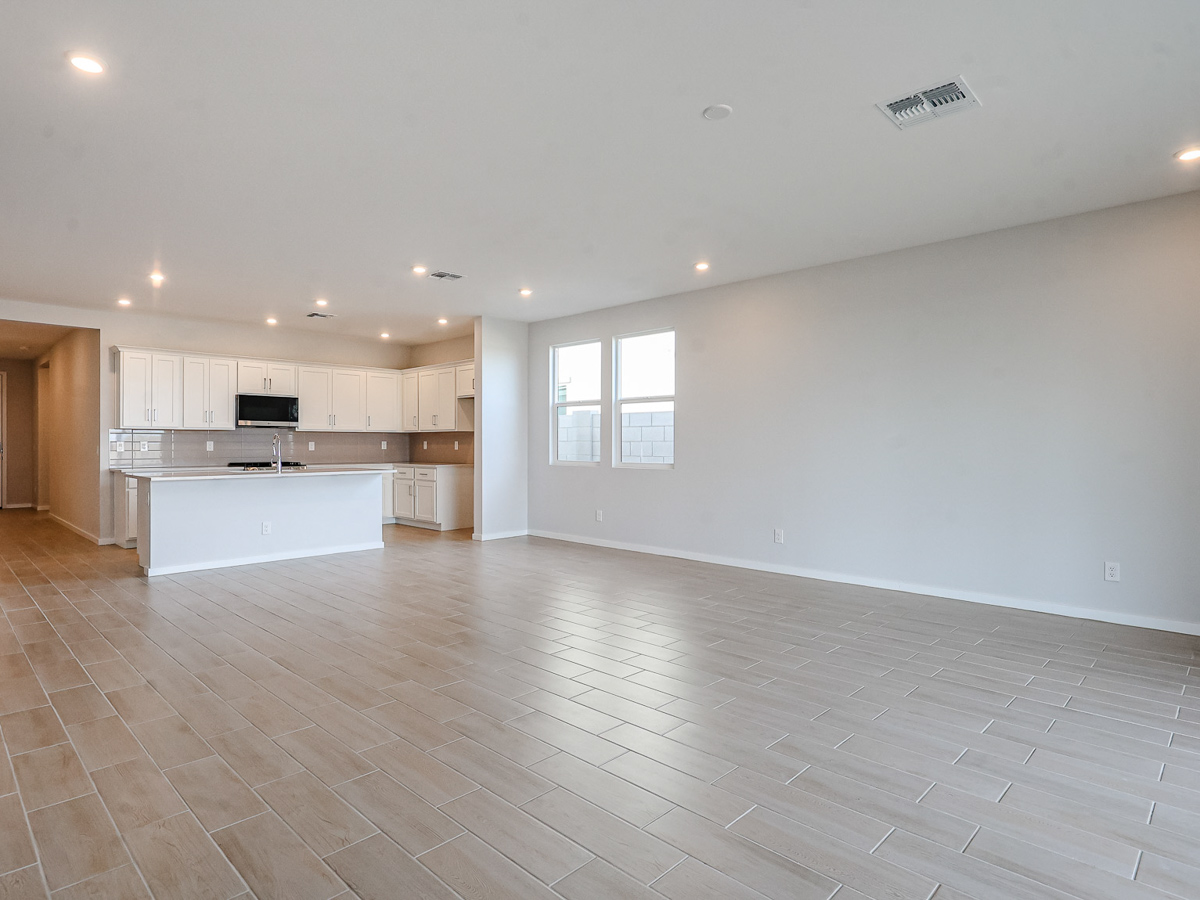 A large empty room with a wood floor and white walls.