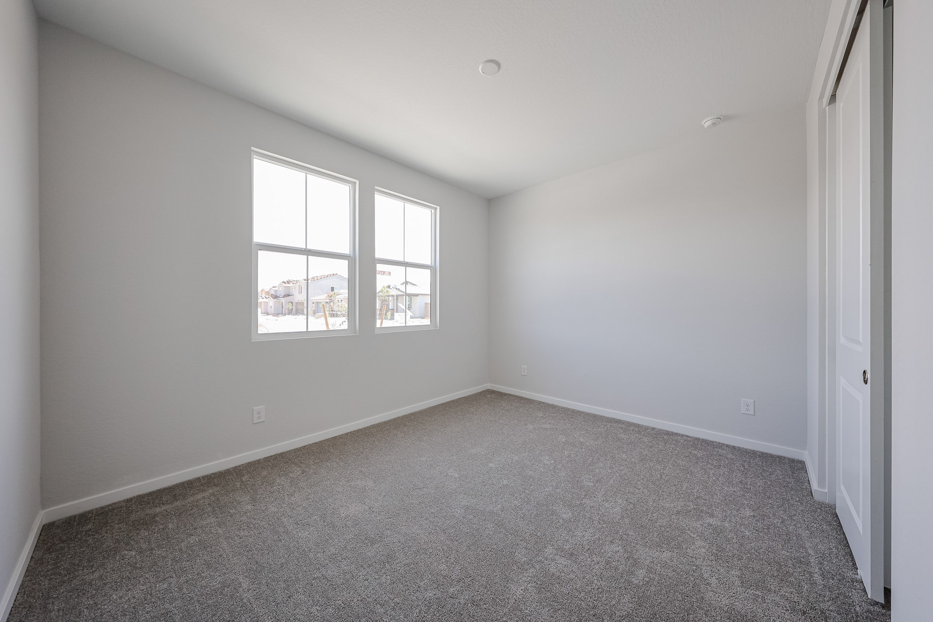 A room with a window and a carpet.