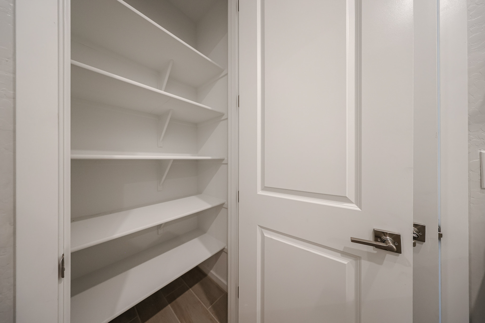A white closet with white doors.