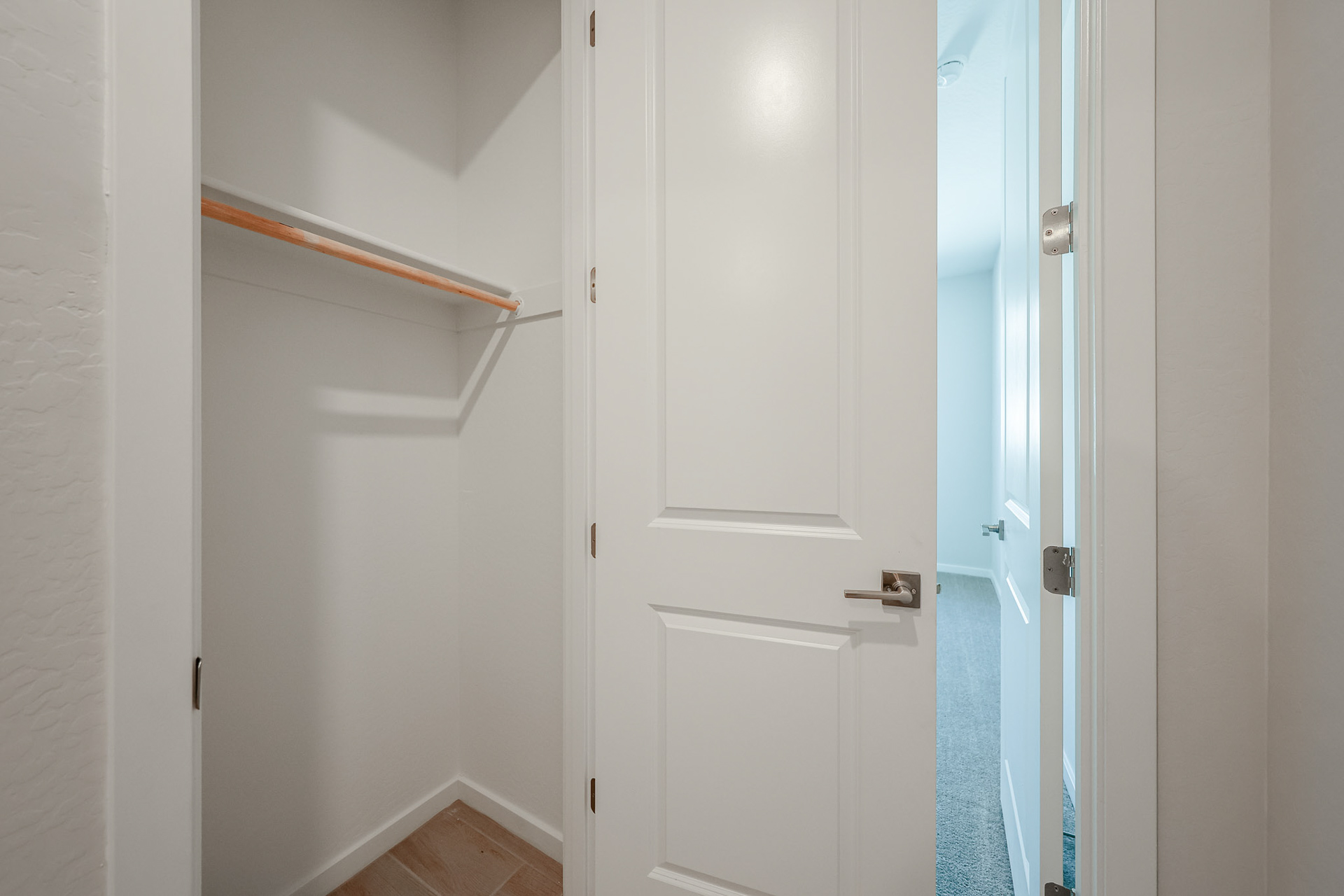 A white door with a blue towel from it.