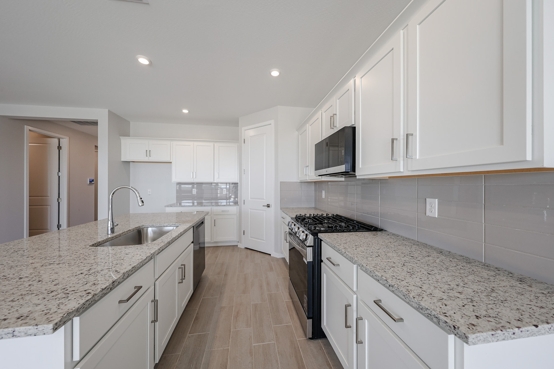 A kitchen with white cabinets.