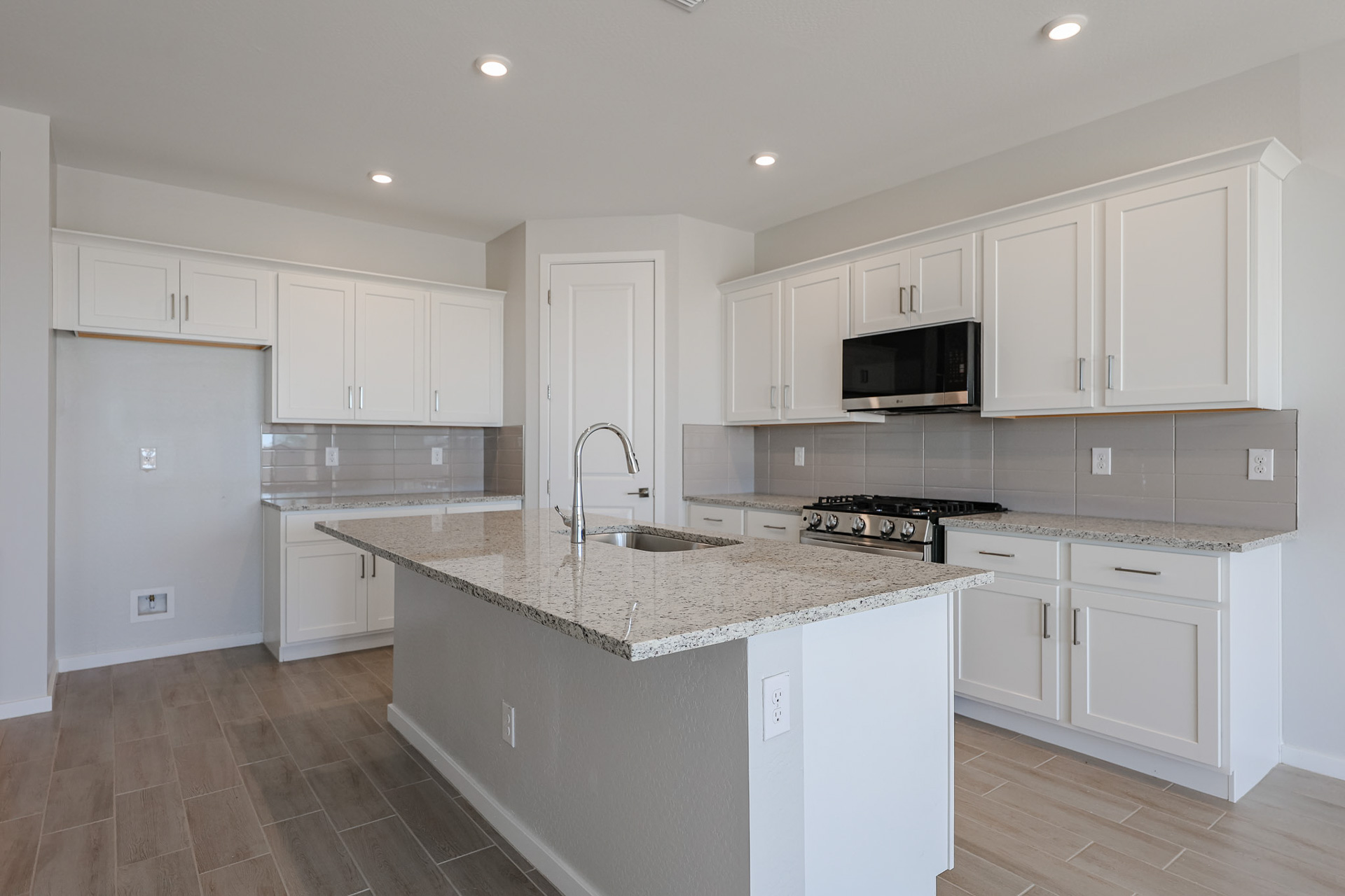 A kitchen with white cabinets.