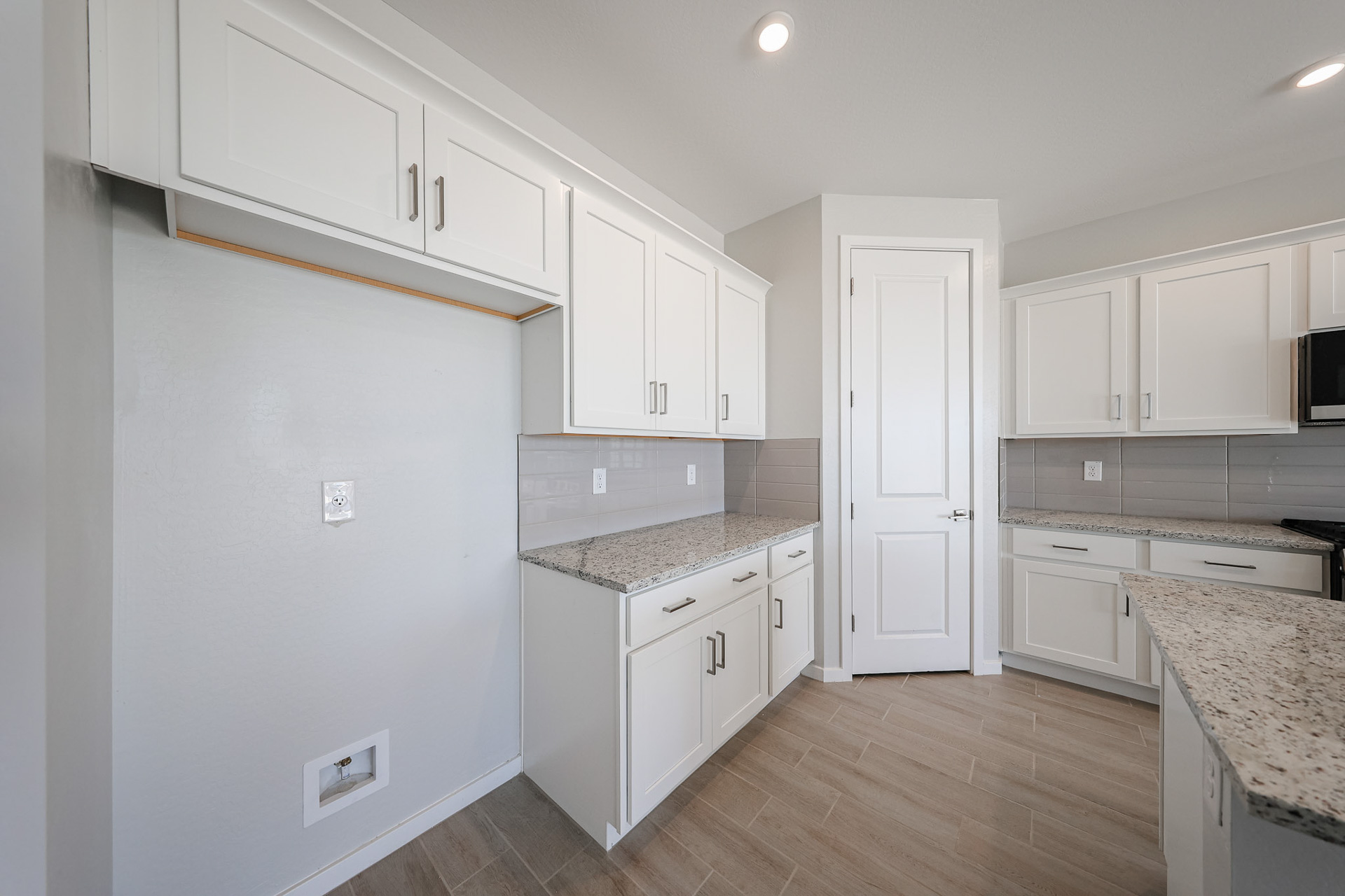 A kitchen with white cabinets.