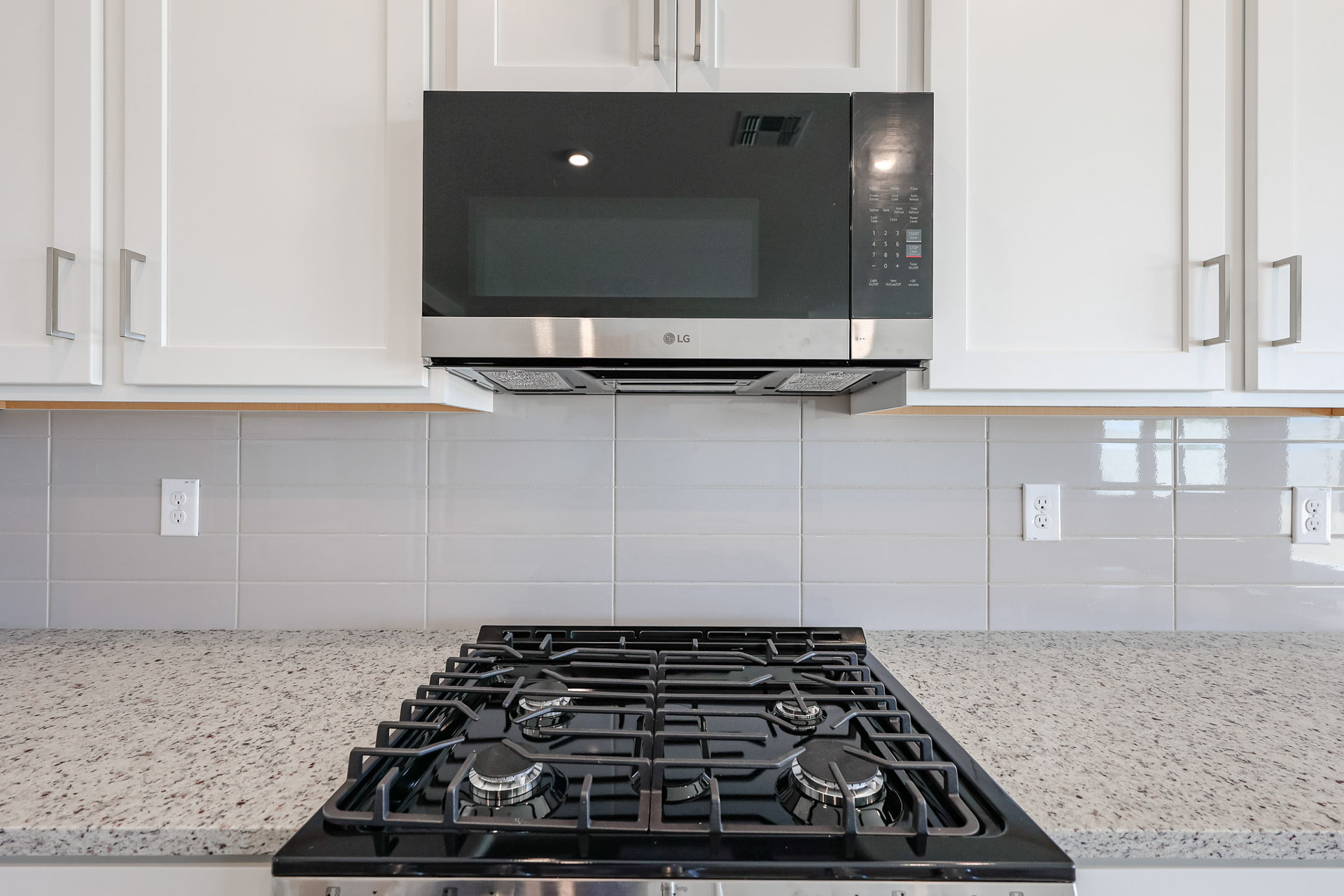 A kitchen with a stove and microwave.
