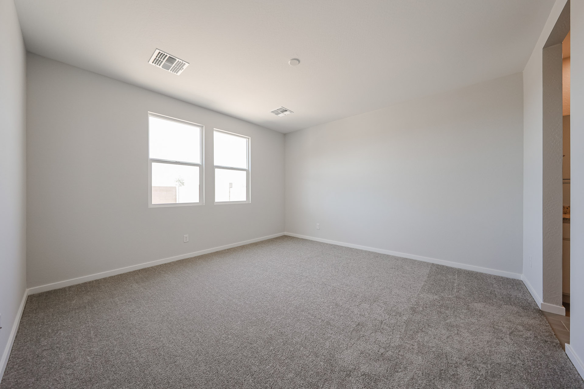 A room with a carpet and windows.