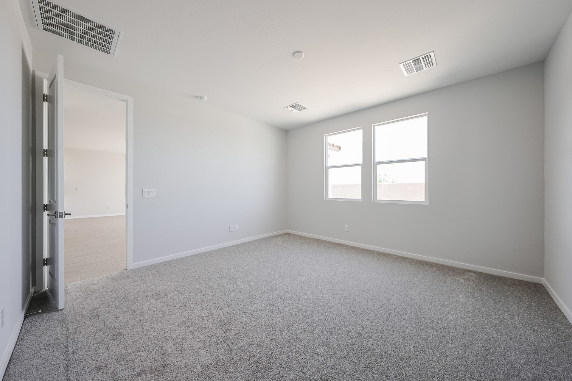 A room with a carpet and windows.