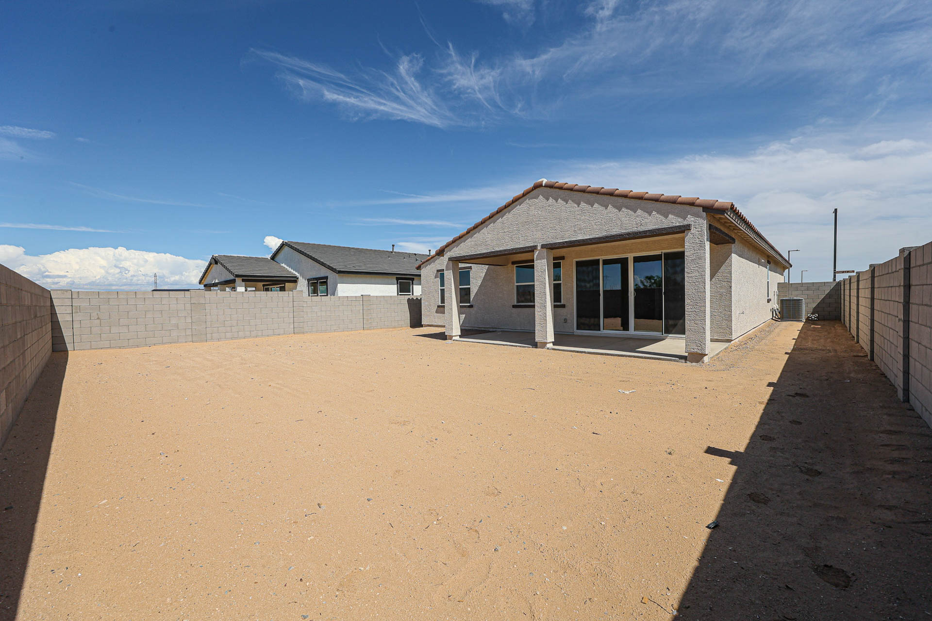A dirt road with a building on the side.
