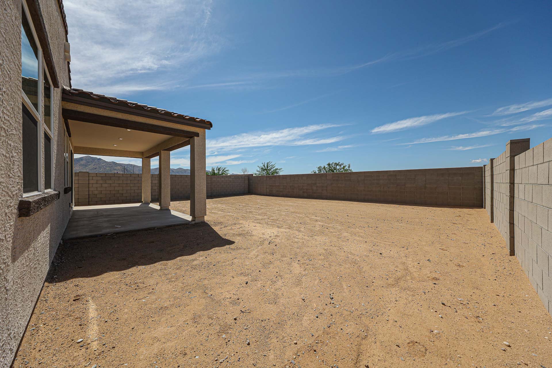 A dirt area with a building in the background.