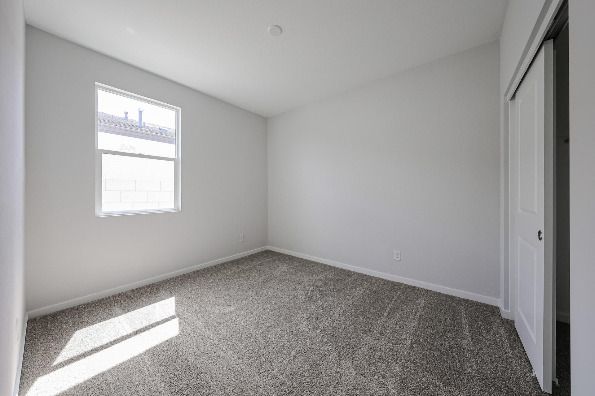 A room with a carpet and a window.