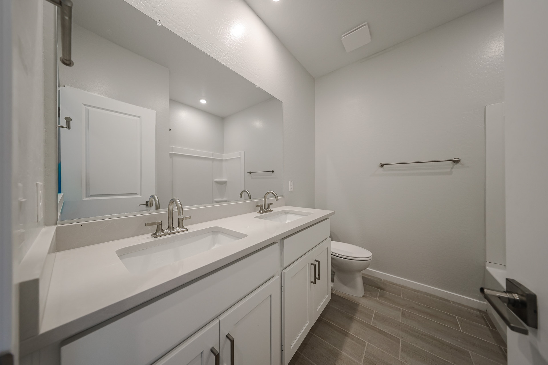 A bathroom with a sink toilet and mirror.