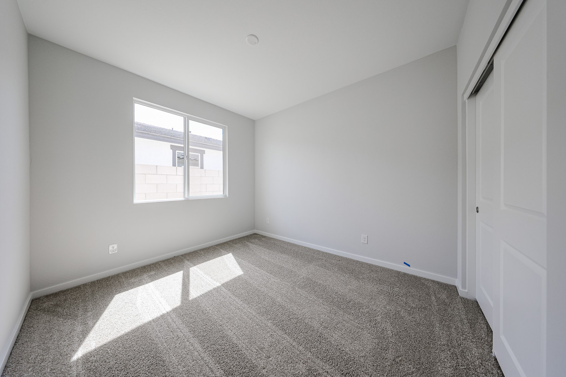 A room with a window and a rug.