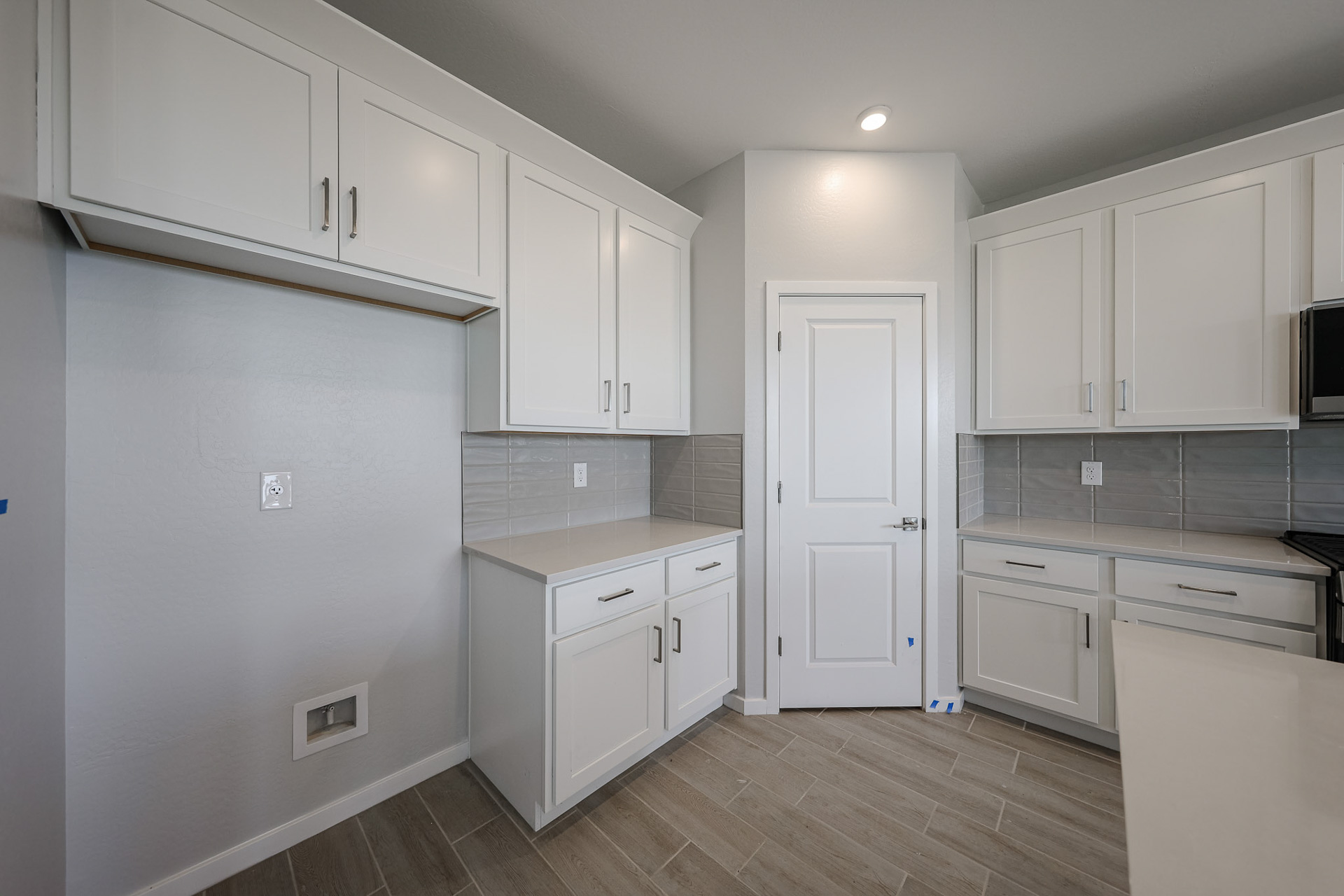 A kitchen with white cabinets.