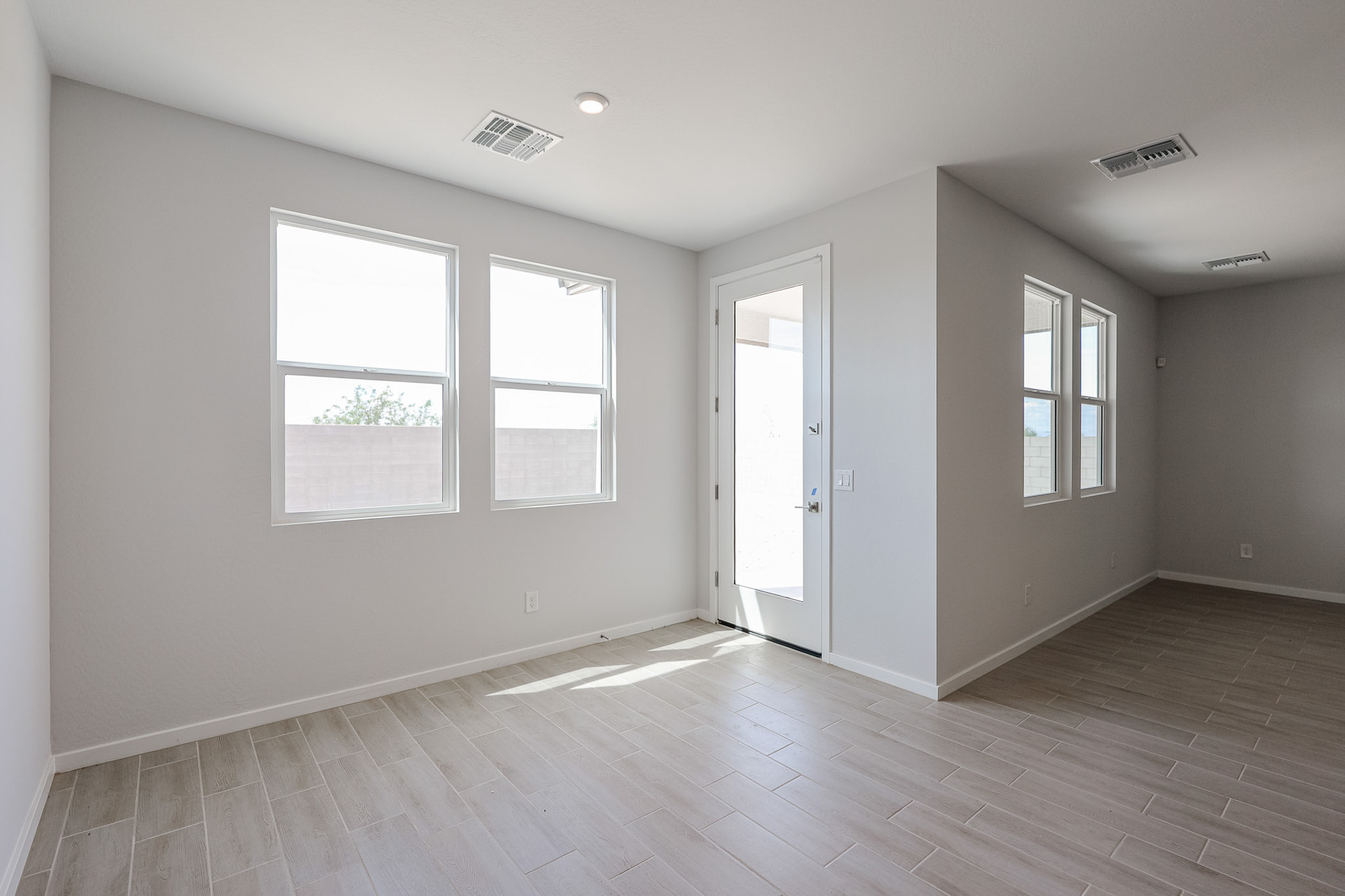 A room with windows and wood floors.