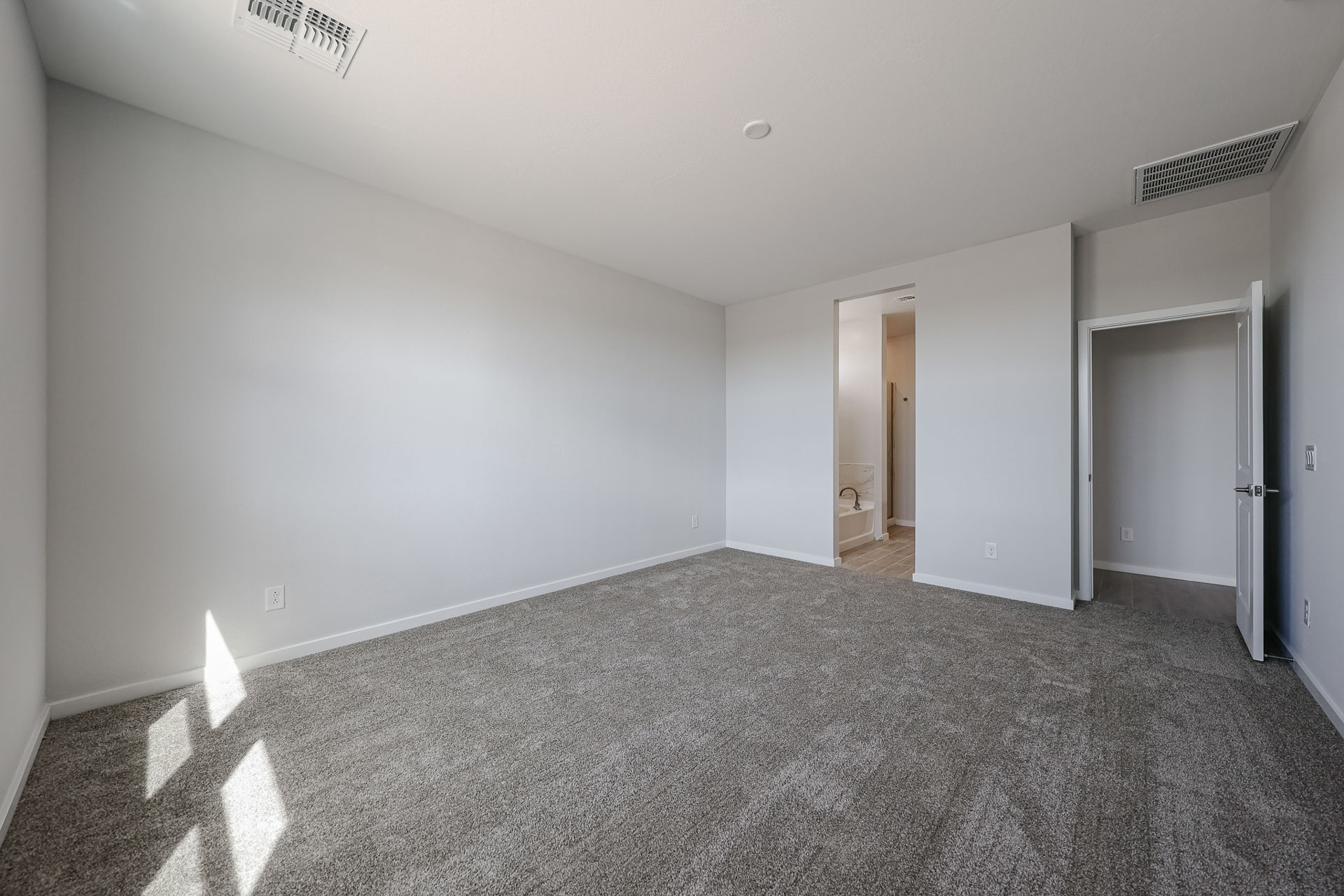 A room with a carpet and a door.