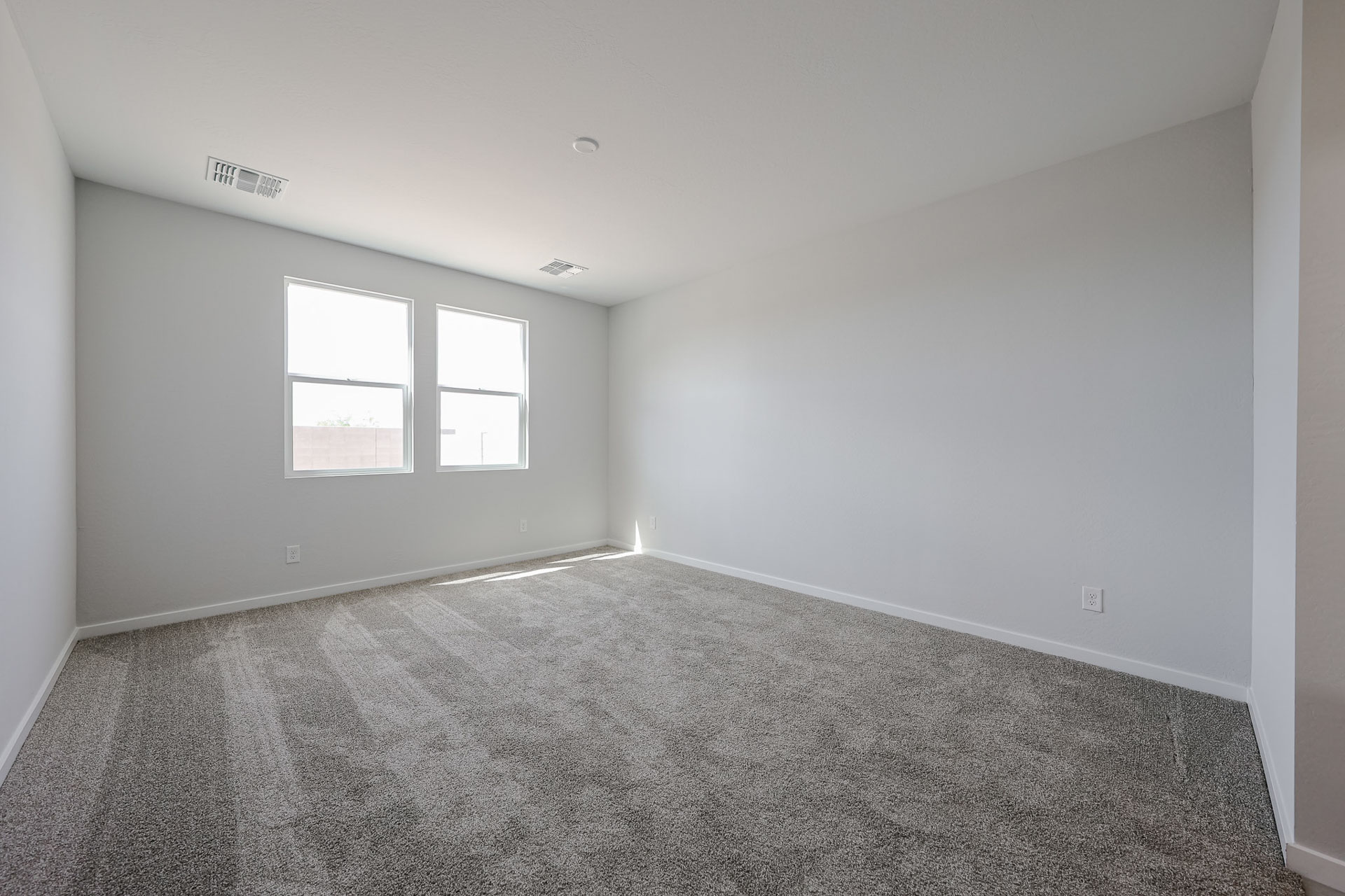 A room with a carpet and windows.