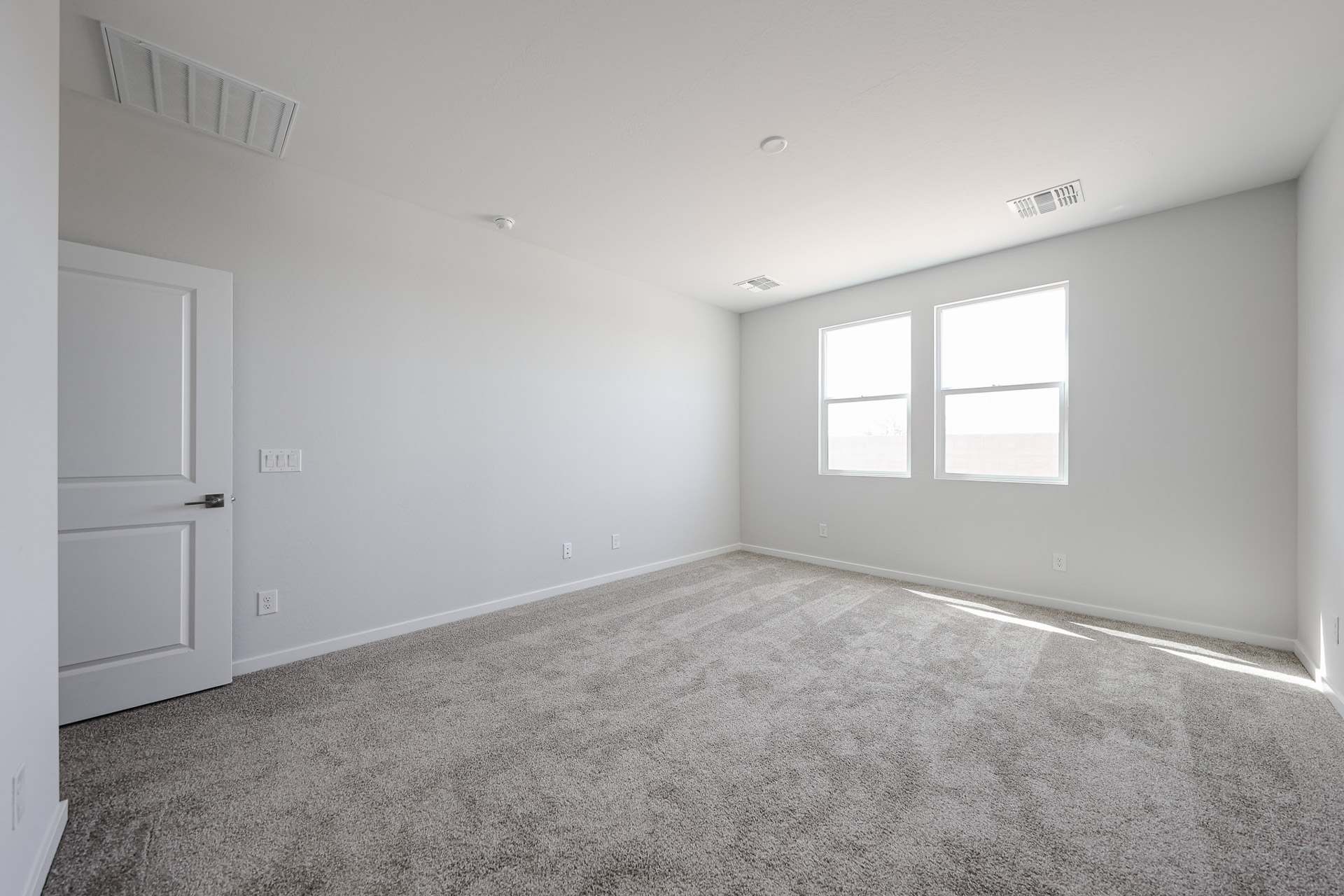 A room with a carpet and a door.