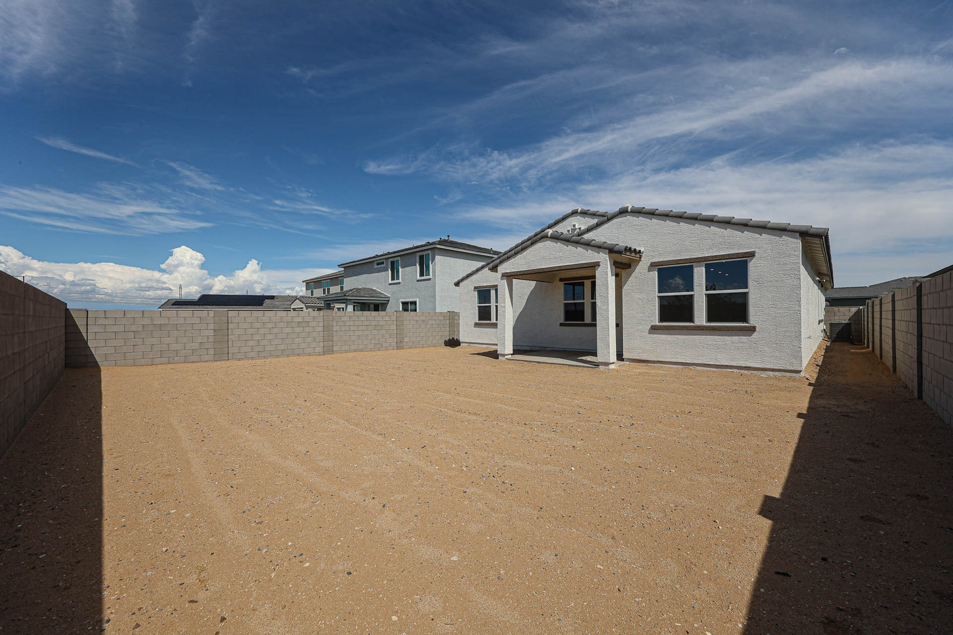A dirt road with buildings on the side.