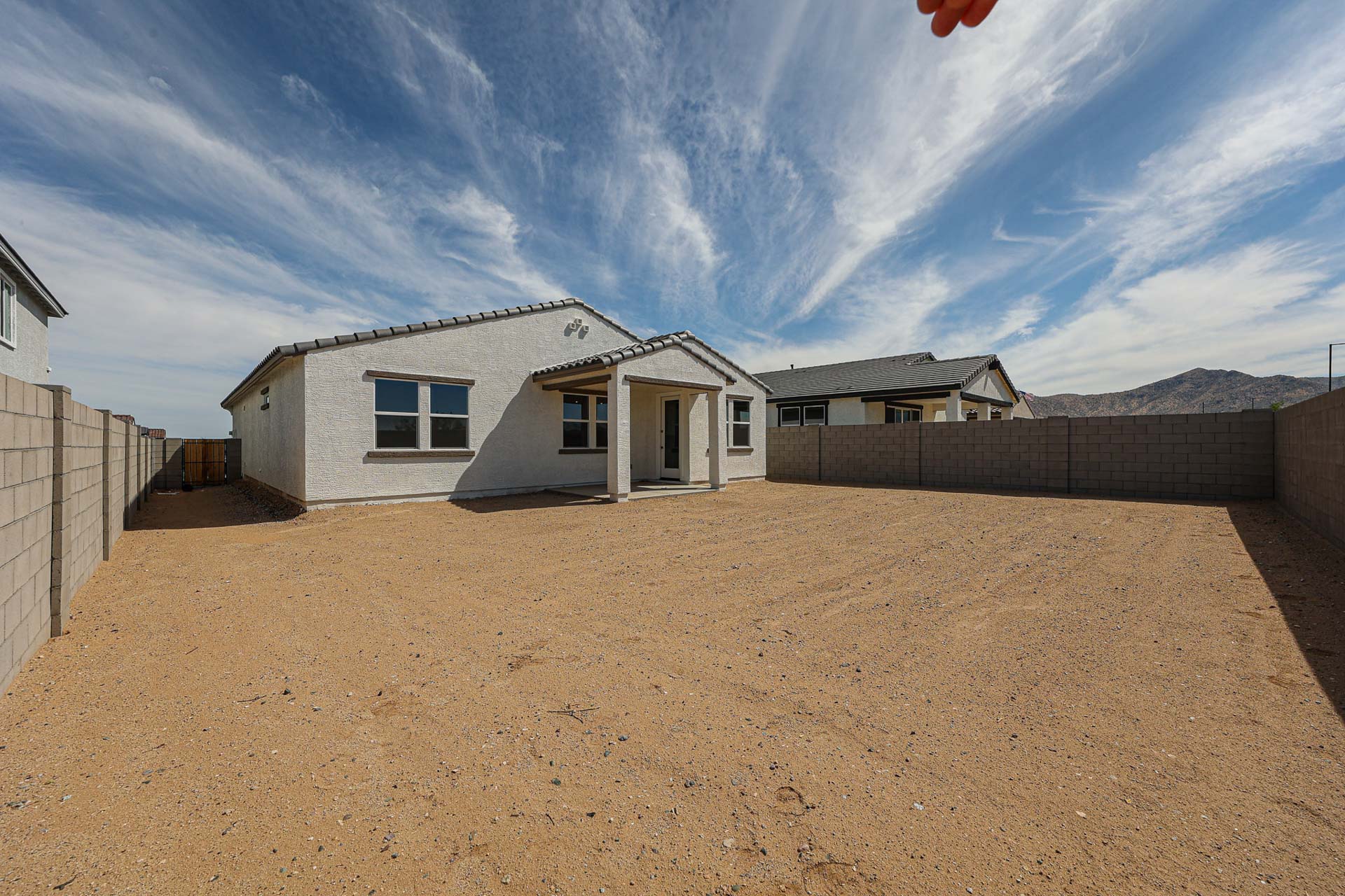 A dirt area with buildings in the background.