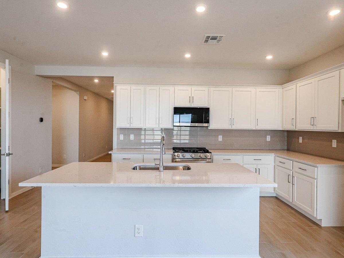 A kitchen with white cabinets.