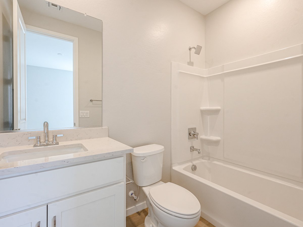 A bathroom with a tub sink and toilet.