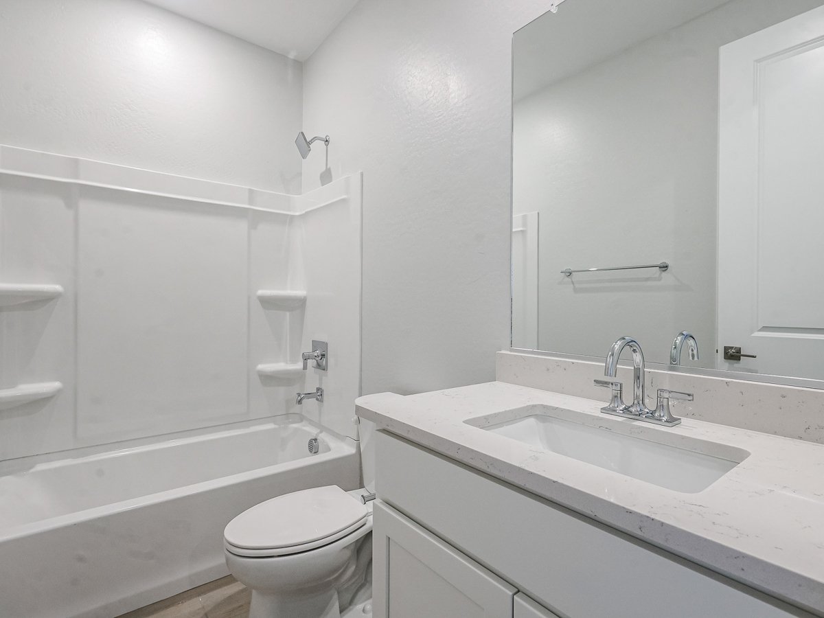 A bathroom with a tub sink and toilet.