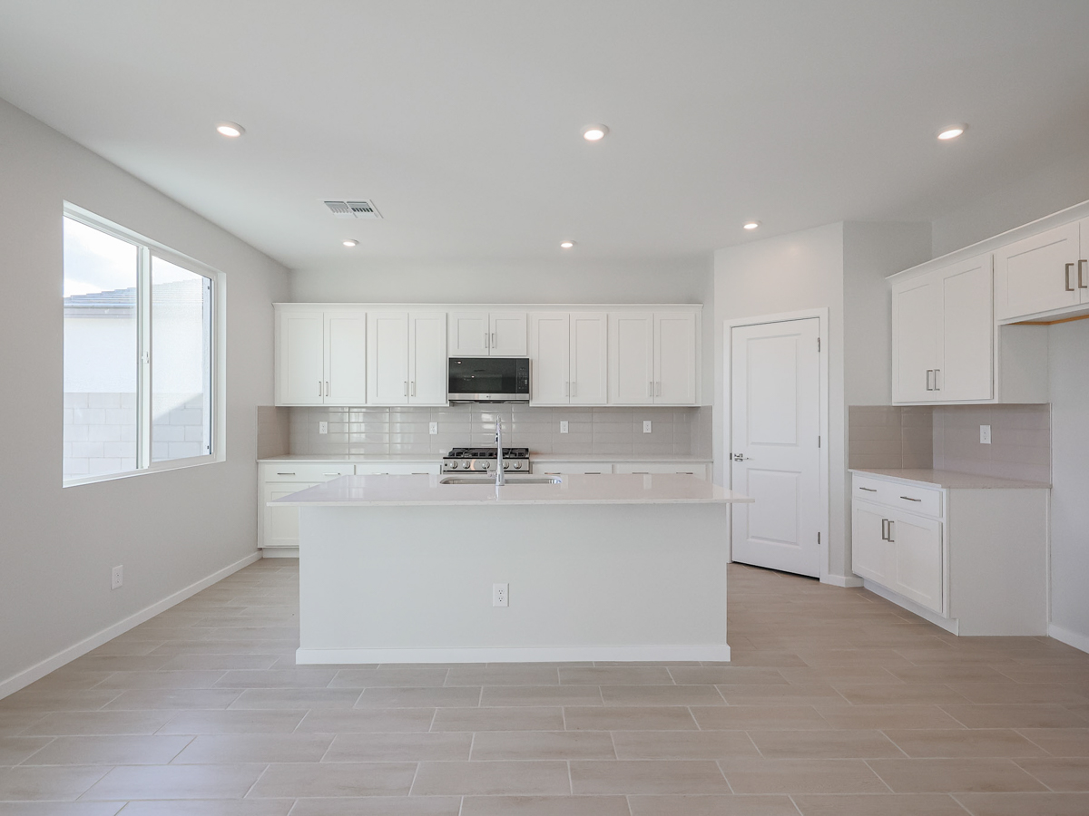 A kitchen with white cabinets.
