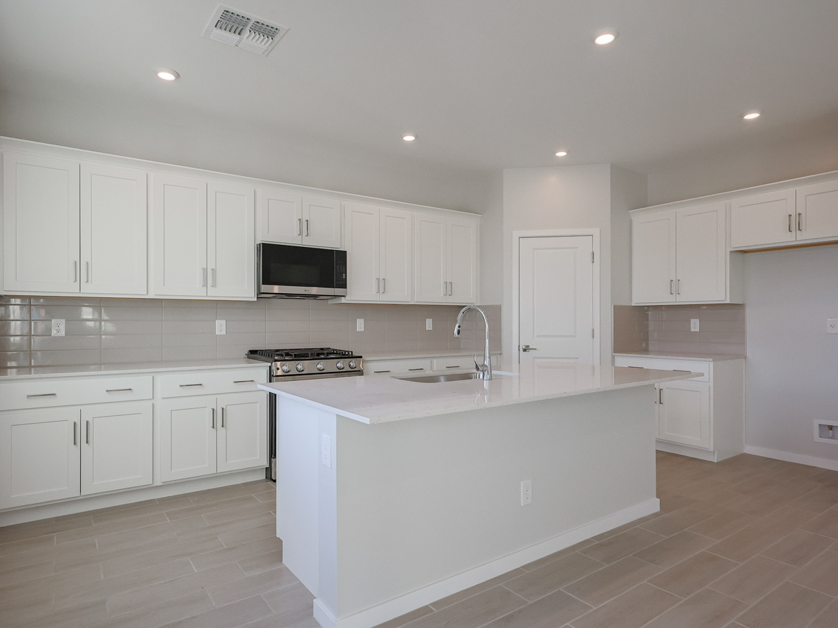 A kitchen with white cabinets.