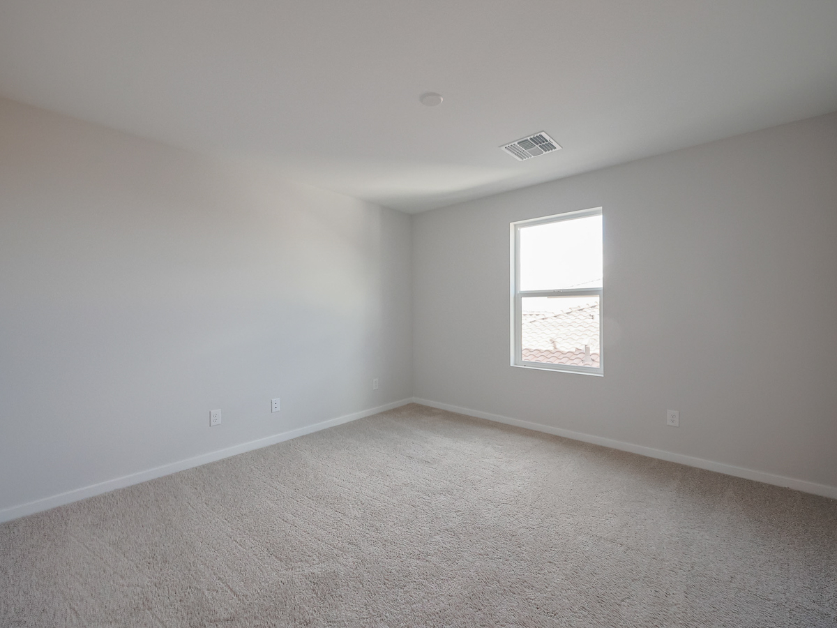 A room with a window and a carpet.