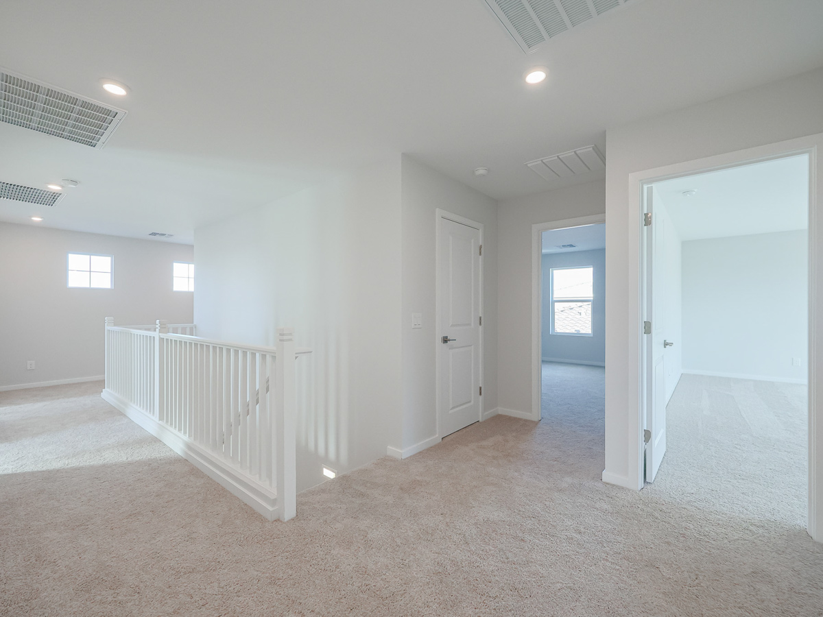A room with white walls and a white railing.