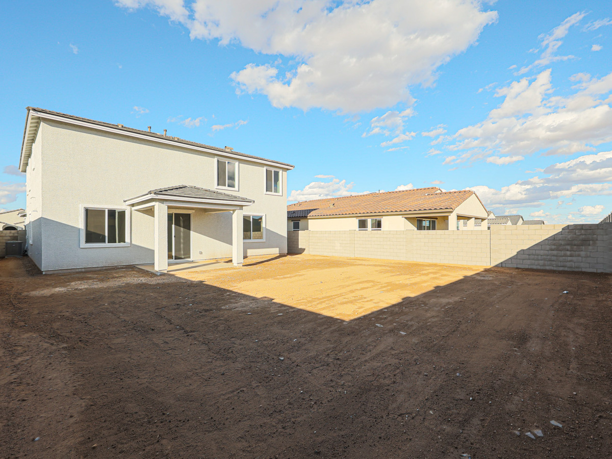 A dirt road leading to a house.