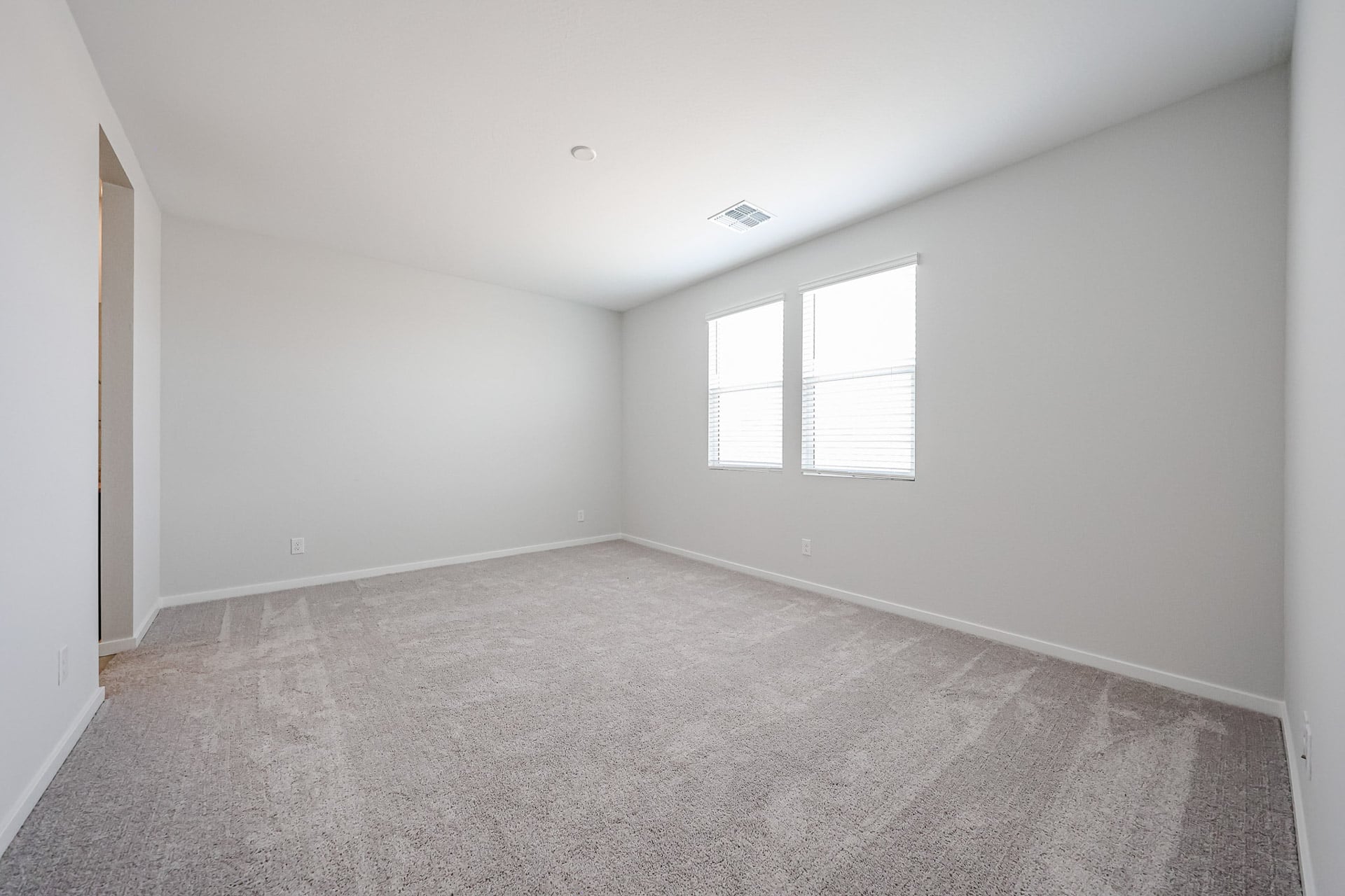 A room with a carpet and windows.