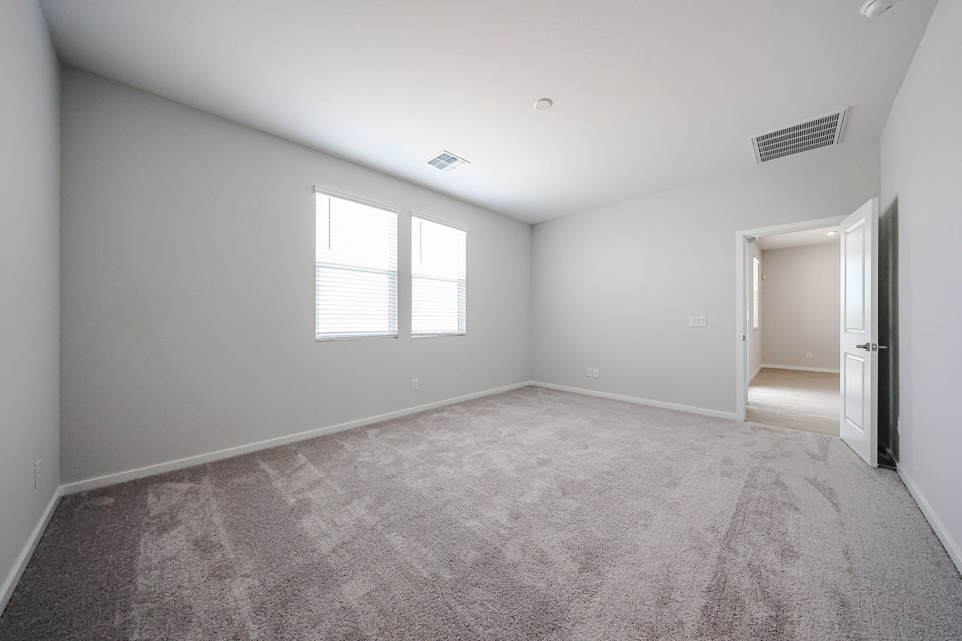 A room with a carpet and windows.
