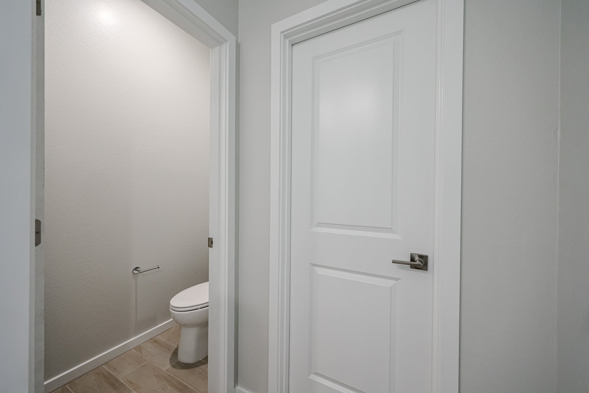 A white door next to a toilet.
