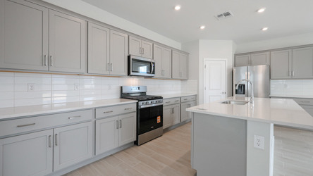 A kitchen with white cabinets.