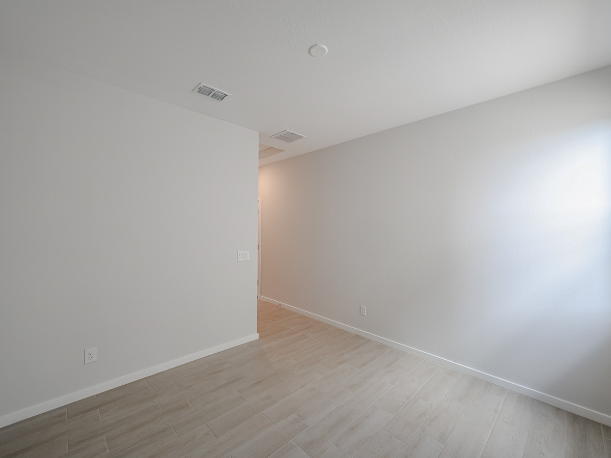 A room with a wood floor and white walls.