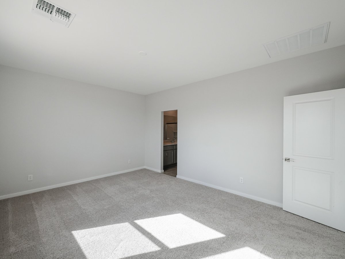 A room with a white door and a white wall.